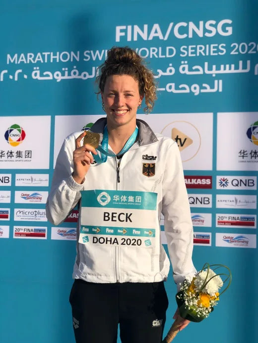 Leonie Beck holding a gold medal at the Marathon Swim World Series in Doha